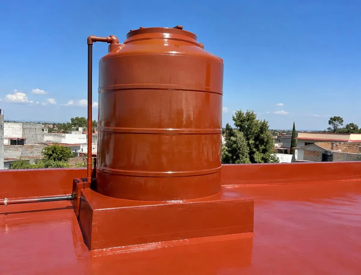 Tinaco en azotea recién sellado con recubrimiento rojo